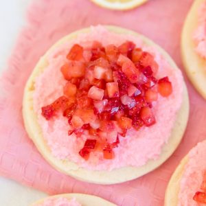 zesty lemon cookie topped in creamy frosting and freshly diced strawberries